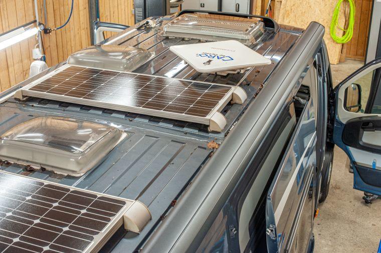 Dachansicht eines ausgebauten Kastenwagens in der Werkstatt mit zwei Solarmodulen